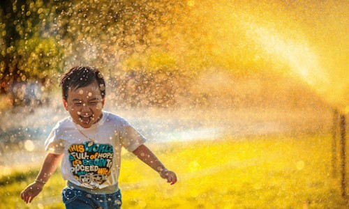 Inexpensive summer activities: enjoy an afternoon of sprinkler fun.